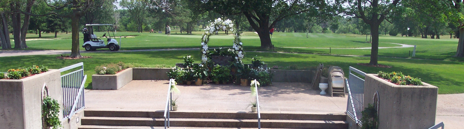 Concrete stairs leading up to the golf course view with a ceremony garland with white flowers in centerframe 